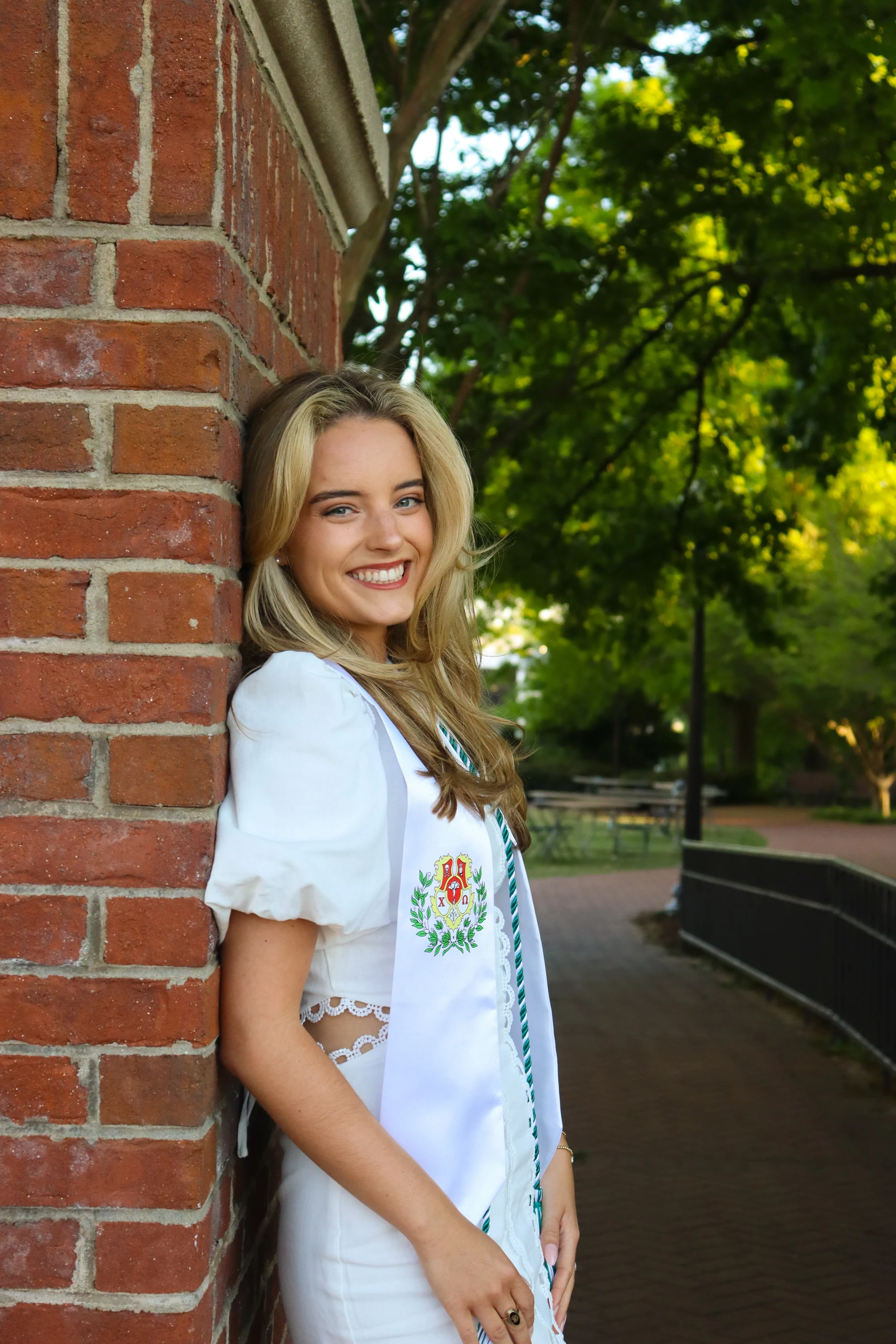 Graduation portrait beside a brick wall