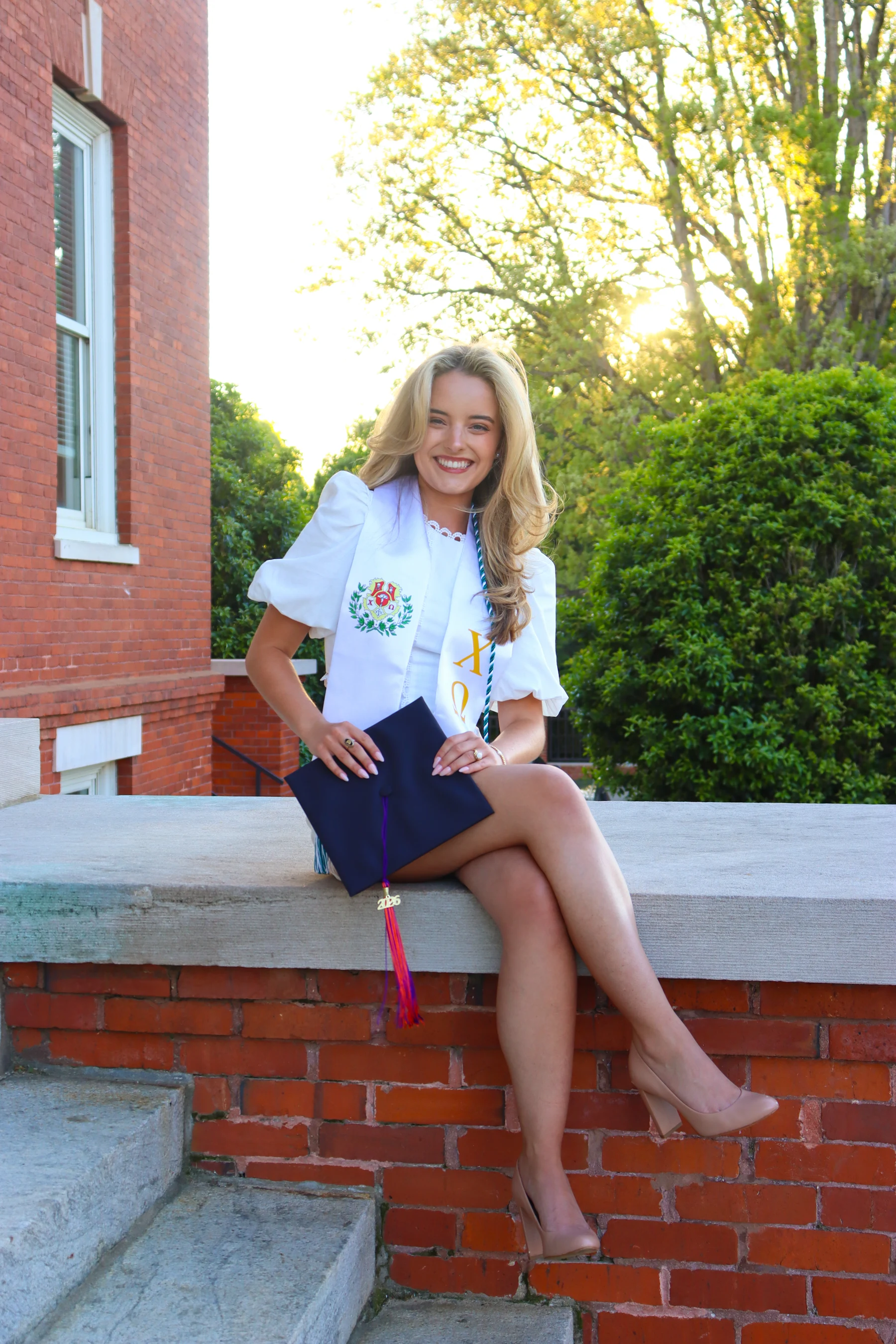 Graduate seated on campus steps